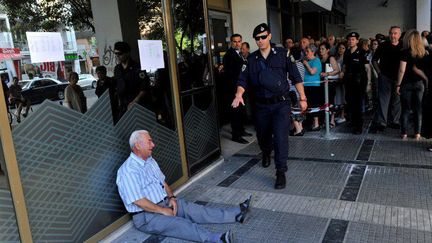 La photo est terrible, elle a fait le tour du monde. Elle est devenue «LA» photo qui symbolise la crise grecque. Le photographe, Sakis Mitrolidis, explique : «Giorgos Chatzifotiadis, 77 ans, s'était rendu dans trois agences bancaires de Thessalonique, la deuxième ville grecque, pour retirer 120 euros sur le compte de son épouse. En vain, car les trois succursales étaient fermées. La quatrième fois, la banque était ouverte mais il a été éconduit. Alors il a craqué. Nous sommes retournés ensemble à la banque, et l'employé a heureusement pu résoudre son problème. Un peu plus tard, il s'est confié à moi. Son malaise allait bien au-delà de sa situation personnelle: "Je croise mes concitoyens mendiant quelques centimes pour acheter du pain. Je vois les suicides qui augmentent. Je suis une personne sensible. Je ne peux pas supporter de voir mon pays dans cette situation. L'Europe, comme la Grèce, a fait des erreurs. Nous devons trouver une solution". Un peu plus tard, il poursuivait: «c'est pour ça que j'étais abattu, plus que par mon problème personne». (AFP Photo / Sakis Mitrolidis )