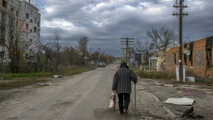 Une femme marche dans les rues d'Arkhanhelske, dans la région de Kherson (Ukraine), le 3 novembre 2022.&nbsp; (BULENT KILIC / AFP)