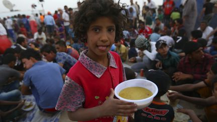 Une petite Irakienne se tient parmi des r&eacute;fugi&eacute;s ayant quitt&eacute; la ville de Mossoul (Irak), assi&eacute;g&eacute;e par les jihadistes, le 29 juin 2014. (© STRINGER IRAQ / REUTERS / X80014)