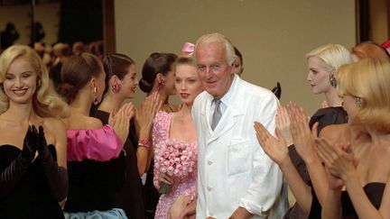 Le couturier français Hubert de Givenchy, applaudi par ses modèles après un défilé à Paris, le 11 juillet 1995. (LIONEL CIRONNEAU / AP / SIPA)