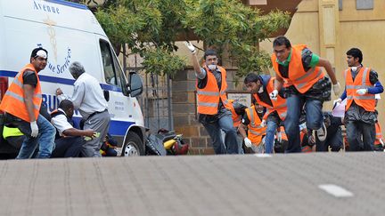 Des civils courent se mettre &agrave; l'abri, le 23 septembre 2013, apr&egrave;s avoir entendu des coups de feu, pr&egrave;s du centre commercial o&ugrave; des islamistes sont retranch&eacute;s avec des otages, &agrave; Nairobi (Kenya). (TONY KARUMBA / AFP)