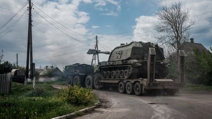 Un véhicule de l'armée ukrainienne chargé sur un transporteur de chars près de Bakhmut, dans l'est de l'Ukraine, le 10 mai 2022. (YASUYOSHI CHIBA / AFP)