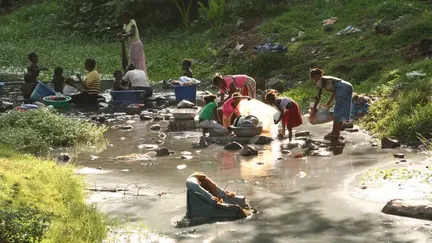 Femmes et enfants faisant la lessive dans une rivière à Mayotte (ISABELLE BONILLO / BIM)