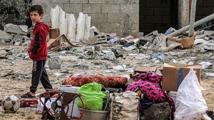 Un enfant se tient dans les rues dévastées de Rafah, dans la bande de Gaza, après un bombardement israélien, le 26 mars 2024. (SAID KHATIB / AFP)