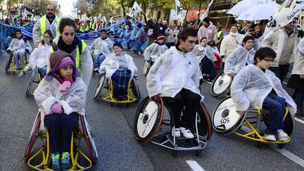 A Madrid, dimanche 2 d&eacute;cembre, des handicap&eacute;s en chaise roulante, des athl&egrave;tes paralympiques et de nombreuses familles brandissaient des mots d'ordre comme "SOS Handicap - Sauvons les droits, l'int&eacute;gration et le bien-&ecirc;tre" ou "Vous allez nous achever avec autant de coupes". (JAVIER SORIANO / AFP)