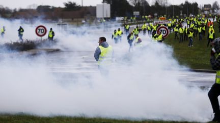 Des "gilets jaunes" à Mondeville (Calvados), près de Caen,&nbsp;au milieu des gaz lacrymogènes. (CHARLY TRIBALLEAU / AFP)