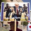 Un homme brandit un visuel généré par IA illustrant une fausse information raciste propagée par Donald Trump, lors d'un rassemblement électoral pour le candidat républicain à Tucson (Arizona), le 12 septembre 2024. (REBECCA NOBLE / AFP)