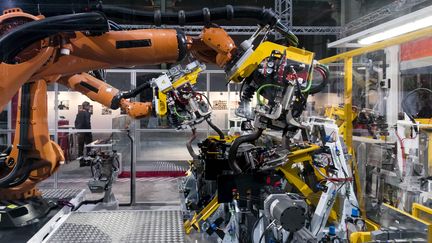 Des bras robotisés interviennent sur la construction d'une machine lors de l'"Usine extraordinaire", exposition au Grand Palais à Paris. (MAXPPP)