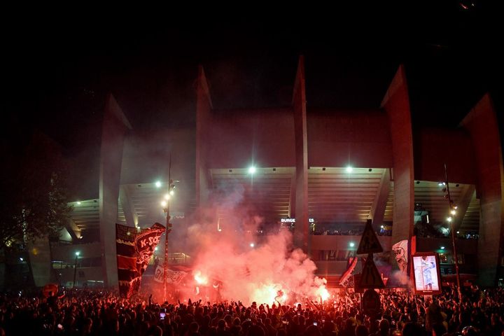 Les supporters parisiens fêtent le dixième titre du PSG en dehors du Parc des Princes, le 23 avril 2022. (JULIEN DE ROSA / AFP)