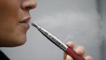 Une femme avec sa cigarette &eacute;lectronique &agrave; Paris, le 5 mars 2013.&nbsp;Pr&egrave;s de 500 000 Fran&ccedil;ais l'auraient d&eacute;sormais adopt&eacute;e. (KENZO TRIBOUILLARD / AFP)