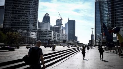 Des passants marchant sur l'esplanade de La Défense, le 16 juillet 2019 près de Paris. (STEPHANE DE SAKUTIN / AFP)