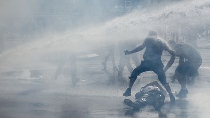 Un manifestant à terre le 14 septembre 2019 à Nantes, après l'utilisation d'un canon à eau par les forces de l'ordre, lors&nbsp;d'une manifestation des "gilets jaunes". (SEBASTIEN SALOM-GOMIS / AFP)