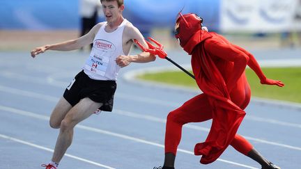 Un homme d&eacute;guis&eacute; en diable pique un coureur lors d'un 5 000 m&egrave;tres durant lesquels les participants doivent &eacute;viter le diable sous peine d'&ecirc;tre &eacute;limin&eacute;s, Edmonton (Canada), le 16 juin 2012. (TODD KOROL / REUTERS)