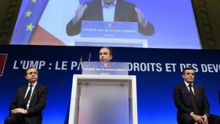 François Fillon (d) et Roger Karoutchi(g) écoutent Jean-François Copé, au siège du parti à Paris, le 25 juin 2011. (AFP - Miguel Medina)