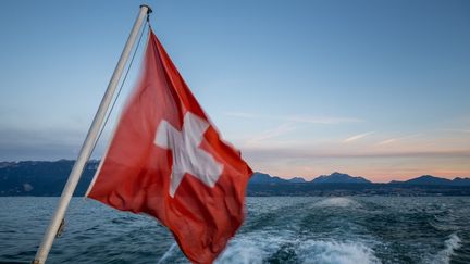 Un drapeau suisse sur un bateau près de Genève (Suisse), le 30 juillet 2023. (FABRICE COFFRINI / AFP)