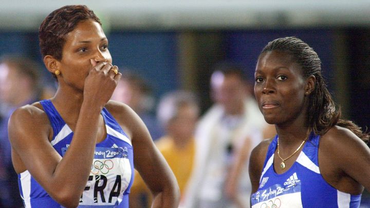 La sprinteuse Fabe Dia (à droite) aux côtés de sa coéquipière Christine Arron, affiche sa déception de terminer 4e du relais 4x100 mètres des Jeux de Sydney, le 30 septembre 2000. (OLIVIER MORIN / AFP)