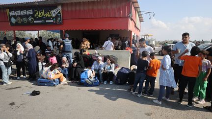 Des habitants de la bande de Gaza avec des passeports étrangers attendent au poste-frontière de Rafah, près de l'Égypte, le 14 octobre 2023. (MUSTAFA HASSONA / ANADOLU)