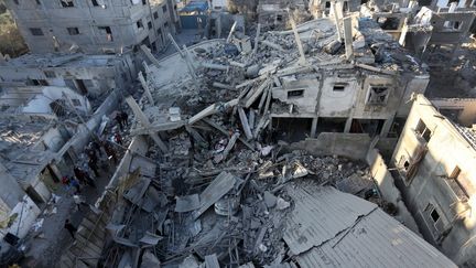 Palestinians inspect the damage caused by Israeli strikes on the Zawayda area, in the center of the Gaza Strip, December 30, 2023. (AFP)