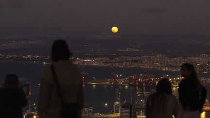 Dans la baie d'Haïfa, des Israéliens se sont retrouvés pour admirer la Lune du Castor au-dessus de la frontière entre l'Etat hébreu et le Liban, où les combats se déroulent depuis plusieurs semaines, le 16 novembre 2024. (FRANCISCO SECO/AP/SIPA / SIPA)