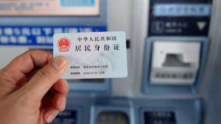 Un passager utilise sa carte d'identité pour acheter un billet de train à Qionghai (Chine), le 26 août 2013. (MENG ZHONGDE / IMAGINECHINA / AFP)