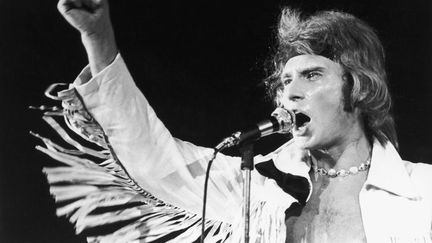 Veste à franges, bandeau autour de la tête et collier de perles au cou, Johnny Hallyday donne un concert au Palais de sports de Paris, le 13 mai 1969. (REG LANCASTER / HULTON ARCHIVE)