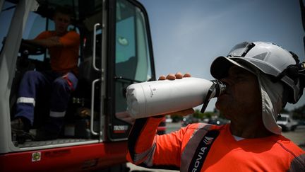 Un homme s'hydrate sur un chantier à Mérignac (Gironde), le 14 juin 2022. (PHILIPPE LOPEZ / AFP)