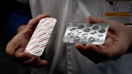 Un soignant de l'Institut hospitalo-universitaire de Marseille avec des comprimés de chloroquine et d'hydroxychloroquine. (GERARD JULIEN / AFP)