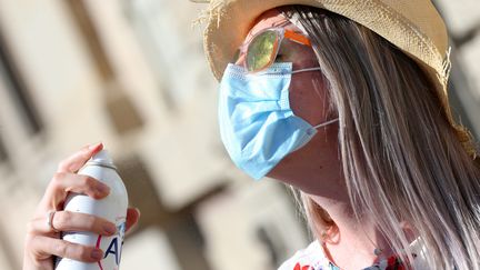 Une femme avec chapeau, lunettes de soleil et masque,&nbsp;se rafraîchit&nbsp;avec un brumisateur, à Colmar (Haut-Rhin), le 15 septembre 2020. (VANESSA MEYER / MAXPPP)