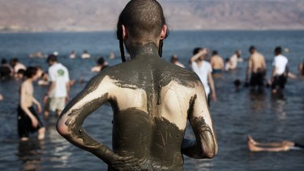 Un juif ultra-orthodoxe en vacances sur les bords de la mer Noire (Isra&euml;l)&nbsp;se recouvre le corps de boue, le 17 ao&ucirc;t 2014. (MENAHEM KAHANA / AFP)