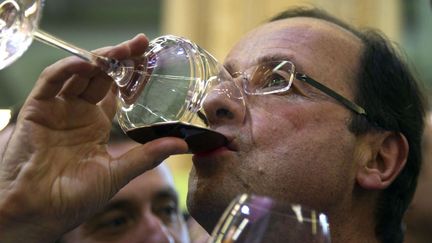 Le candidat socialiste Fran&ccedil;ois Hollande boit du vin rouge sur un stand du Salon de l'agriculture &agrave; Paris, le 28 f&eacute;vrier 2012. (CHARLES PLATIAU / AP / SIPA)