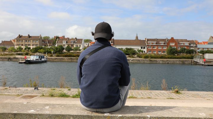 Lucky*, 28 ans, attend que son téléphone se charge et espère pouvoir retenter bientôt une traversée de la Manche, à Calais (Pas-de-Calais), le 17 septembre 2024. (ELOISE BARTOLI / FRANCEINFO)