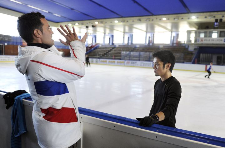 Romain Haguenauer donne des consignes à Daisuke Takahashi à l'entraînement dans la patinoire de Lyon, le 11 août 2011. (PHILIPPE DESMAZES / AFP)