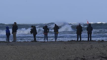 Des personnes observent les vagues à Saint-Malo (Ille-et-Vilaine), le 27 décembre 2017. (DAMIEN MEYER / AFP)