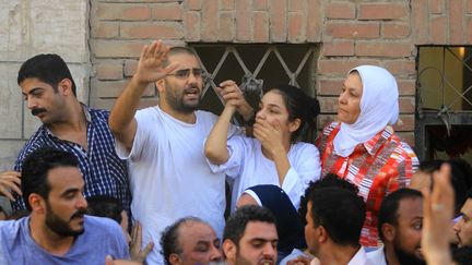 Les militants pro-d&eacute;mocratie Alaa Abdel Fattah et sa s&oelig;ur Sanaa Seif (en haut, au centre), lors des fun&eacute;railles de leur p&egrave;re, au Caire (Egypte), le 28 ao&ucirc;t 2014. (HASAN MOHAMED / AFP)