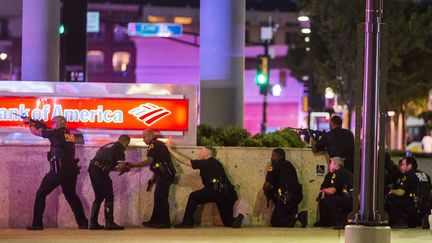 Des policiers se prot&egrave;gent apr&egrave;s avoir &eacute;t&eacute; vis&eacute;s par des tirs en marge d'un rassemblement contre la violence polici&egrave;re &agrave; Dallas (Texas, Etats-Unis), le 7 juillet 2016. (SIPA / AP)