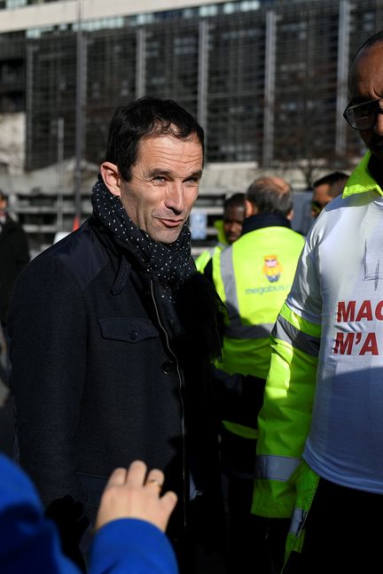 Benoît Hamon auprès des employés de Megabus, devant le ministère de l'Économie et des Finances à Paris, le 18 novembre 2016 (LIONEL BONAVENTURE / AFP)