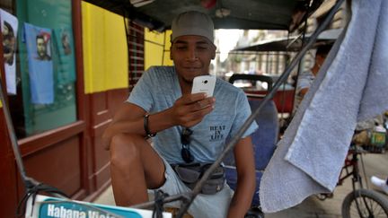 Un Cubain avec son téléphone portable, à La Havane, le 6 décembre 2018 (photo d'illustration) (YAMIL LAGE / AFP)