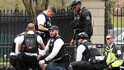 Des policiers neutralisent un homme qui a tenté de s'immoler par le feu près de la Maison Blanche, à Washington (Etats-Unis), le 12 avril 2019. (CARLOS BARRIA / REUTERS)