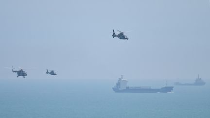 Des hélicoptères et des navires de l'armée chinoise au large de Taïwan, le 4 août 2022. (HECTOR RETAMAL / AFP)