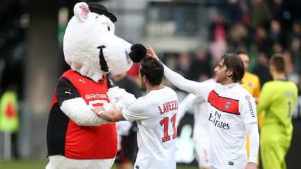 Ezequiel Lavezzi et Maxwell, joueurs du PSG, font ami-ami avec la mascotte du Stade Rennais, lors du match entre les deux &eacute;quipes, le 6 avril 2013.&nbsp; (JOHN BERRY / GETTY IMAGES)