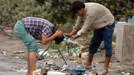 Des migrants tentent de se laver dans la "jungle" de Calais, le 11 ao&ucirc;t 2015. (MAXPPP)