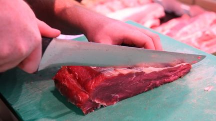 Un boucher découpe un faux filet de boeuf. Photo d'illustration. (JEAN-FRANCOIS FREY / MAXPPP)