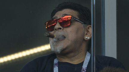 Diego Maradona savoure un cigare dans une tribune non-fumeur du stade du Spartak Moscou, le 16 juin 2018 lors du match Argentine-Islande. (JUAN MABROMATA / AFP)