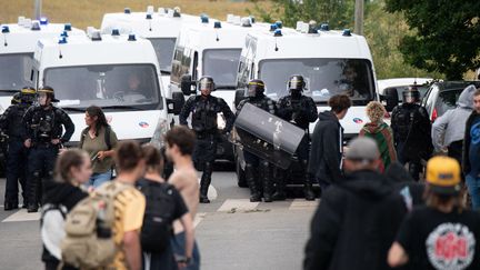 Des policiers évacuent des fêtards après une rave party illégale dans un champ à Redon (Ille-et-Vilaine), le 19 juin 2021. (LOIC VENANCE / AFP)