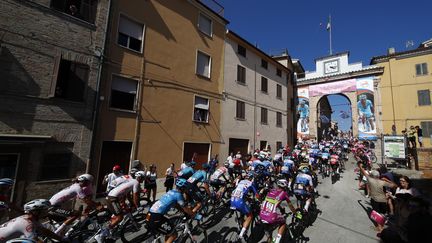 Le peloton lors du Tour d'Italie 2022, dans les rues de Filottrano, le 17 mai 2022. (LUCA BETTINI / AFP)