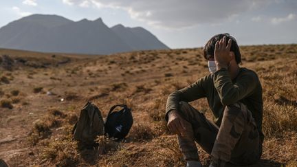 Un migrant afghan attend des passeurs à l'est de la Turquie&nbsp;après avoir traversé à pied la frontière avec l'Iran, en août 2021. Photo d'illustration. (OZAN KOSE / AFP)