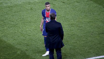 Kylian Mbappé en discussion avec son entraîneur Mauricio Pochettino, le 28 avril 2021 au Parc des Princes. (JEAN CATUFFE / AFP)