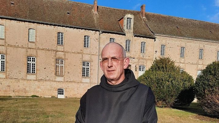 Le père-prieur Benoît Joseph, devant l'abbaye de Solignac, en Haute-Vienne.&nbsp; (JEROME JADOT / RADIO FRANCE)