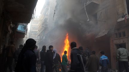 Des habitants d'Alep constatent les d&eacute;g&acirc;ts d'un bombardement a&eacute;rien sur cette ville du nord de la Syrie, le 15 d&eacute;cembre 2013. (MOHAMMED AL-KHATIEB / AFP)