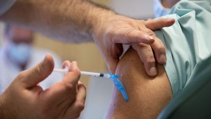 Un médecin administre une dose de vaccin contre le Covid-19 Pfizer-BioNtech à un soignant de l'hôpital Ambroise Paré de Boulogne-Billancourt (Hauts-de-Seine), le 6 janvier 2021. (THOMAS SAMSON / AFP)